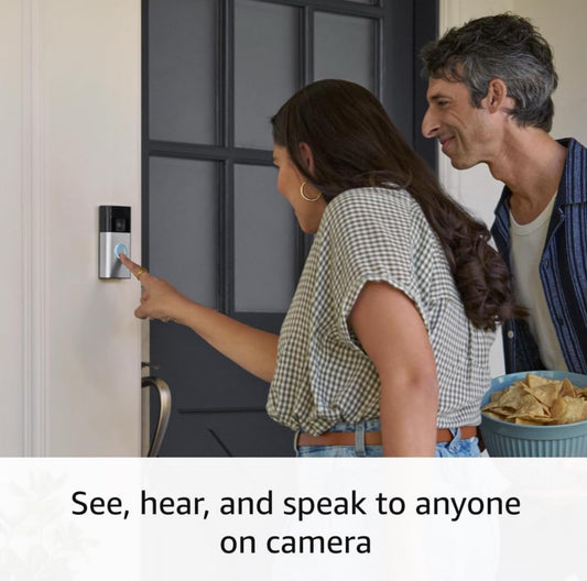 Mujer usando el New Ring Wireless Doorbell, viendo y hablando con alguien en cámara frente a la puerta.